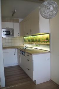 uma cozinha com armários brancos e um balcão com uma janela em Apartment Schluchsee em Schluchsee