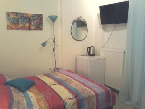 ein Schlafzimmer mit einem Bett mit einer Lampe und einem Spiegel in der Unterkunft Persephone's Project in Iraklio