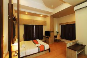 a bedroom with a bed and a desk and a television at The Contrast i Hotel in Pluak Daeng
