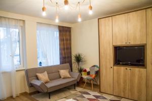 a living room with a couch and a flat screen tv at Boem Studio in Braşov