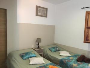 Pokój z 2 łóżkami i stołem z lampką w obiekcie Casa Rural Paloma w mieście Benajarafe
