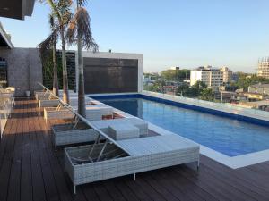 a swimming pool with lounge chairs on a building at Apollonia Royale Hotel in Angeles