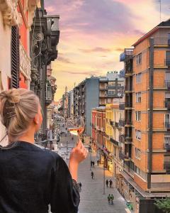 een vrouw die een glas wijn drinkt in een stadsstraat bij Fourooms - Bari Sparano in Bari