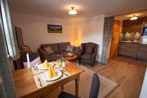 a living room with a table and a couch at Rostalm in Berchtesgaden