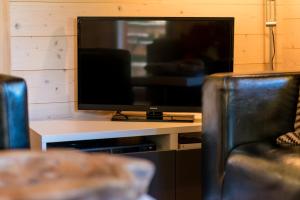TV de pantalla plana en la parte superior de una mesa en 3-Schlafzimmer Chalet Eichhorn****, Saas Fee 1800m, en Saas-Fee
