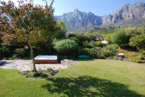 un giardino con vasca idromassaggio nel mezzo di un cortile di Kingsbury Cottage a Breërivier