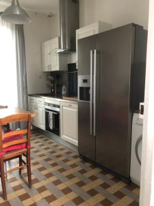 a kitchen with a stainless steel refrigerator and a table at Joffre in Fontainebleau