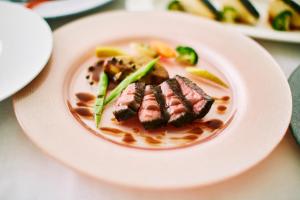 a plate of food with meat and vegetables on a table at Wakanoura Nature Resort Epicharis in Wakayama