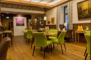 a restaurant with green chairs and a table at Das Waldhotel - Genuss & Wellness am Notschreipass in Todtnau