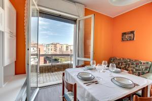 een eetkamer met een tafel en een groot raam bij Smart Mestre centre in Mestre