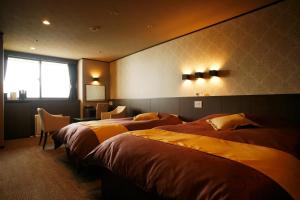 
a hotel room with two beds and two lamps at Hotel Kanronomori in Niseko
