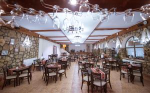 Hanul Hora Romaneasca- camere de inchiriat في إيفوري سود: مطعم فيه طاولات وكراسي في الغرفة