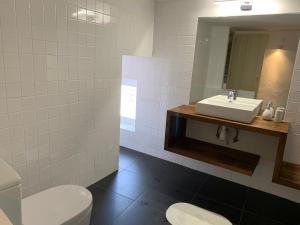 a bathroom with a sink and a toilet and a mirror at Casa do Castelo in Castelo de Vide