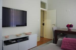 sala de estar con TV en una pared blanca en My Home in Lisbon, en Lisboa