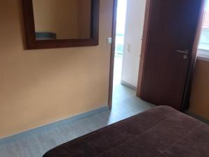 Schlafzimmer mit einem Bett, einem Spiegel und einer Tür in der Unterkunft House on the Beach in Machico