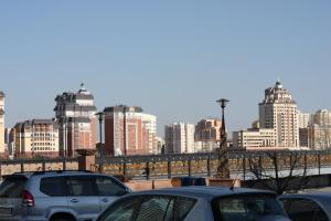 un grupo de coches estacionados frente a una ciudad en Prestige, en Astana