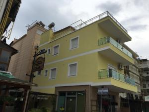 un edificio amarillo con balcón en la parte superior en Apartment Alexis Stefanos, en Himare