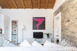 ein Wohnzimmer mit einem weißen Sofa und einem TV in der Unterkunft Lilia's Home in Cernobbio