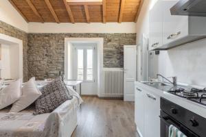 salon z kanapą i kuchnią w obiekcie Lilia's Home w mieście Cernobbio