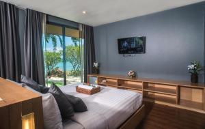 een slaapkamer met een groot bed en een raam bij The Bay Samui in Choeng Mon Beach