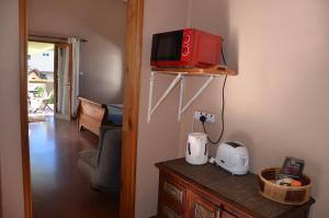 a room with a table with a microwave on a wall at serin du cap in Blue Bay