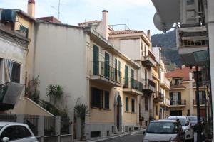 an alley with cars parked on a street with buildings at Gemma del Sud in Scilla