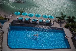 an overhead view of a swimming pool with chairs and umbrellas at Divine Resort & Spa in Rishīkesh