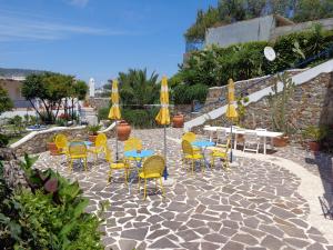 a patio with yellow chairs and tables and umbrellas at Il Mediterraneo - Adults Only in Ponza +60 photos