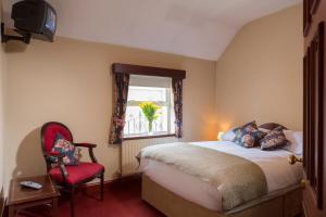 1 dormitorio con cama, silla roja y ventana en O'Donoghue's en Dublín