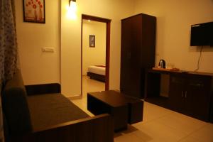 Habitación de hotel con sofá y dormitorio en Palmtree Leaf, Munnar en Munnar