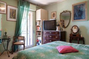 a bedroom with a bed and a tv and a mirror at Carly & Dane Vacation House in Taormina