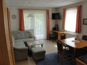 ein Wohnzimmer mit einem Sofa und einem Tisch in der Unterkunft Apartment St. Nikola in Sankt Nikola an der Donau
