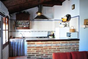 eine Küche mit einer Backsteintheke und einem weißen Kühlschrank in der Unterkunft El Romerito in Zalamea la Real