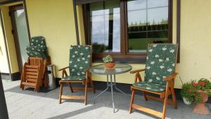 three chairs and a glass table on a patio at Villa Sole in Pruszcz Gdański