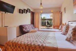 um quarto com uma cama grande e uma televisão em L'Oiseau de L'Ocean Tourist Residence em Flic-en-Flac