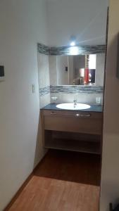 ein Bad mit einem Waschbecken und einem Spiegel in der Unterkunft Departamento Estudio 2 in Neuquén