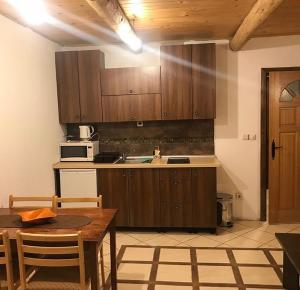 een keuken met houten kasten en een tafel en stoelen bij Villa Popara Kopaonik in Kopaonik