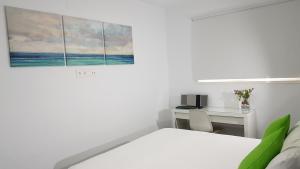Habitación blanca con cama y escritorio en CANARIAS. ISLAS AFORTUNADAS, en Las Palmas de Gran Canaria