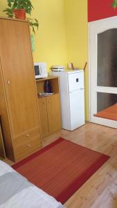 a room with a kitchen with a refrigerator and a microwave at Mediterrán Szállás in Gyula