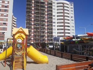 un parque infantil en la arena con un tobogán amarillo en Ballenas desde el balcon en Puerto Madryn