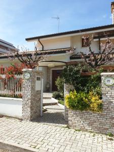 een huis met een bakstenen hek en een stenen loopbrug bij Villa Gioia Rooms in Montegranaro