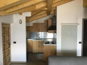 een keuken met houten kasten en een fornuis met oven bij Rifugio Dalco in Sorico