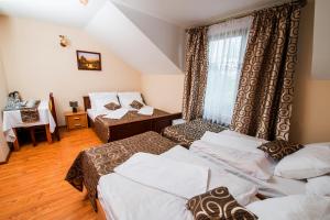 a hotel room with three beds and a window at Nad Bugiem in Hrubieszów