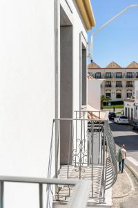 einen Balkon eines Gebäudes mit Metallgeländer in der Unterkunft Apartamento 1º de Maio in Tavira