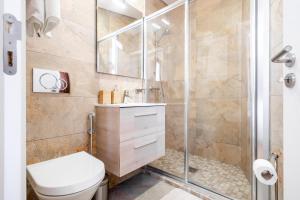 a bathroom with a shower and a toilet and a sink at Apartamento 1º de Maio in Tavira +22 photos