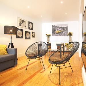 uma sala de estar com duas cadeiras e uma mesa em Arroios de Paixão Duplex em Lisboa
