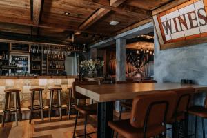 a bar with a table and bar stools at Hotel De4dames in Schiermonnikoog