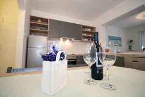 - deux verres à vin et un sac sur une table dans la cuisine dans l'établissement Doleco Apartment, à Opatija