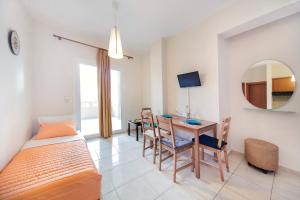 a bedroom with a bed and a desk and a table at Omega Comfy Apartments Almyrida in Almirida