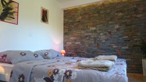 a bedroom with a bed and a brick wall at Guest house Korado in Rovinj